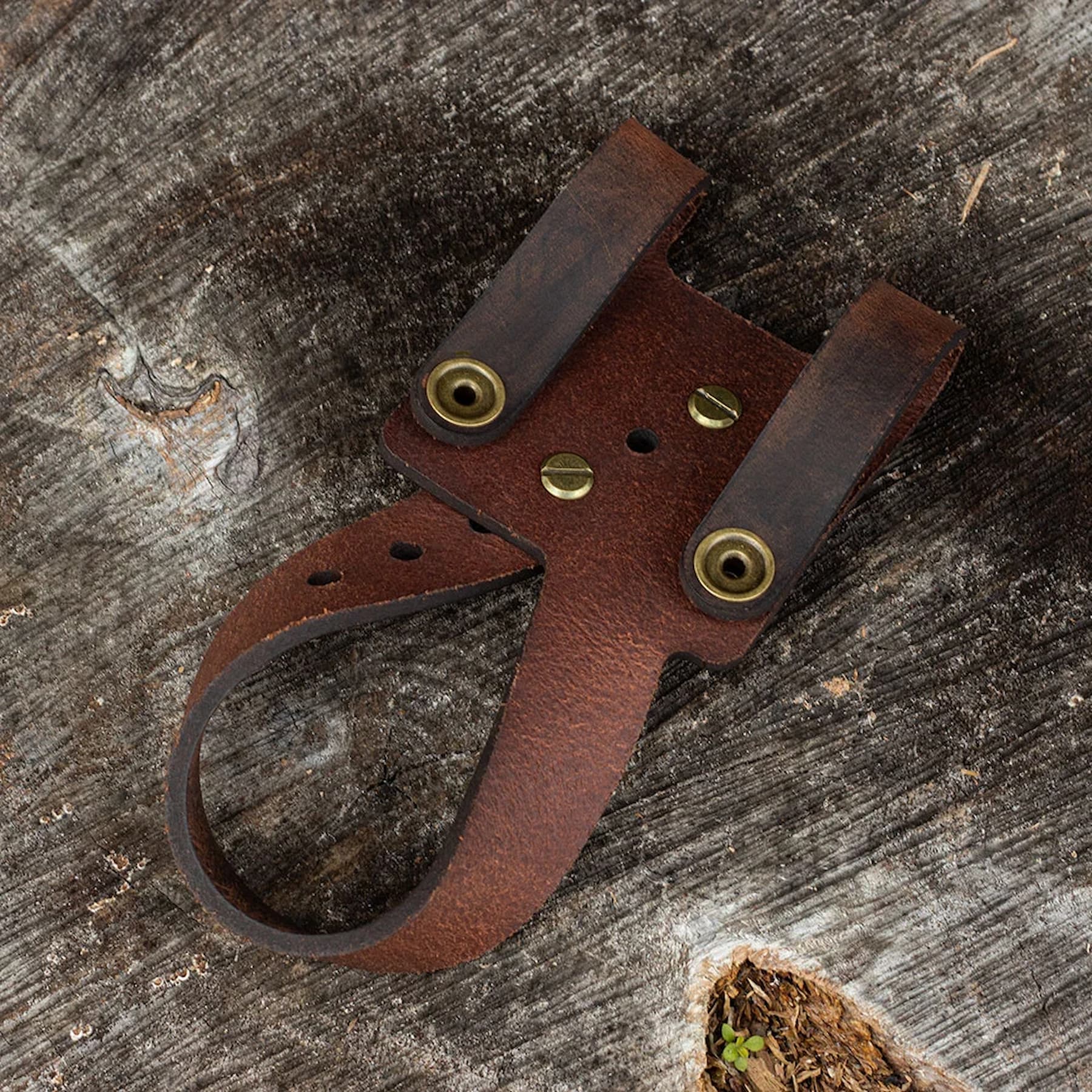 Adjustable leather holster showing size customization for different axes and hatchets